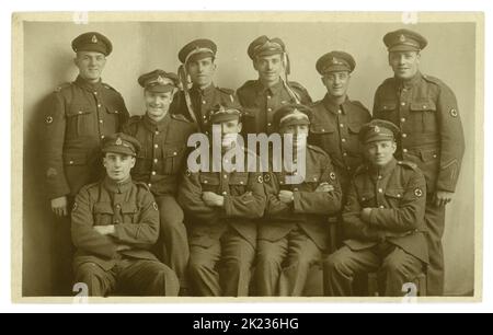 Originalpostkarte aus der Ära WW1, im Studio-Porträt von Kumpels der Royal Army Medical Corps (RAMC) - jubelend und feierlich. Einige haben drapierte Bänder um ihre Mützen, alle lächeln und sind so glücklich. Auf der Rückseite der Postkarte ist 'Taken at Ripon Armistice Day November 11. 1918'. Ripon, Harrogate, North Yorkshire, England, Großbritannien Stockfoto