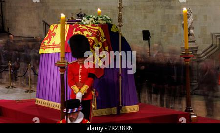 Mitglieder der Öffentlichkeit, die sich durch die Nacht anstellen, gehen am Sarg Ihrer Majestät Königin Elizabeth II. Vorbei, während der verstorbene Monarch im Staat We liegt Stockfoto