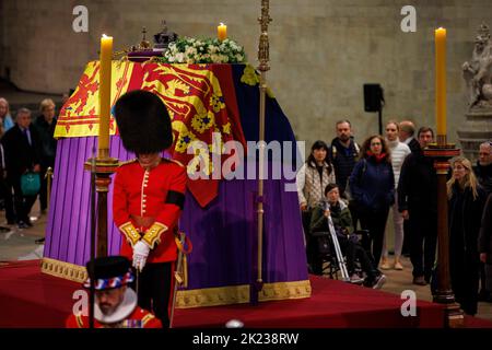 Mitglieder der Öffentlichkeit, die sich durch die Nacht anstellen, gehen am Sarg Ihrer Majestät Königin Elizabeth II. Vorbei, während der verstorbene Monarch im Staat We liegt Stockfoto