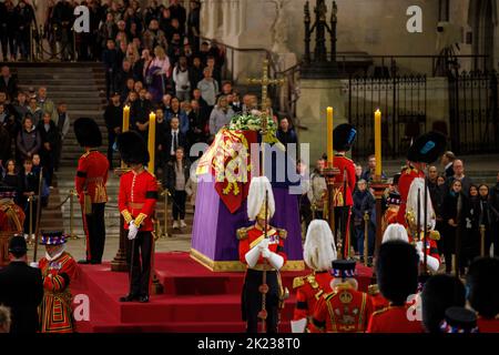 Mitglieder der Öffentlichkeit, die sich durch die Nacht anstellen, gehen am Sarg Ihrer Majestät Königin Elizabeth II. Vorbei, während der verstorbene Monarch im Staat We liegt Stockfoto