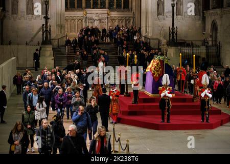 Mitglieder der Öffentlichkeit, die sich durch die Nacht anstellen, gehen am Sarg Ihrer Majestät Königin Elizabeth II. Vorbei, während der verstorbene Monarch im Staat We liegt Stockfoto