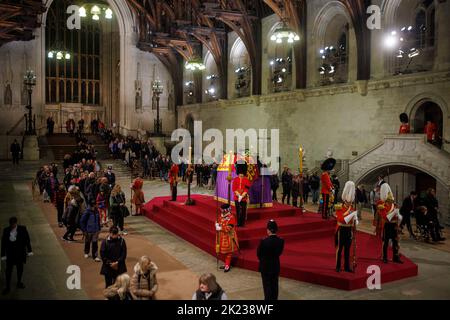 Mitglieder der Öffentlichkeit, die sich durch die Nacht anstellen, gehen am Sarg Ihrer Majestät Königin Elizabeth II. Vorbei, während der verstorbene Monarch im Staat We liegt Stockfoto