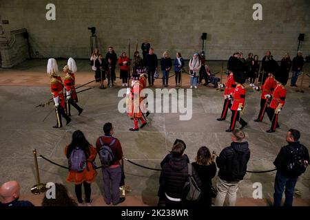 Die Wachablösung findet statt, wenn Mitglieder der Öffentlichkeit, die sich durch die Nacht anstellen, am Sarg Ihrer Majestät Königin Elizabeth II. Vorbeilaufen Stockfoto