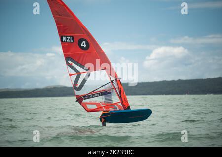 Ein Mann nimmt an einem nationalen Windsurf-Hydrofoil-Rennen beim Waterbourne Watersports Festival, Takapuna Beach, Auckland, Neuseeland, Teil. Stockfoto