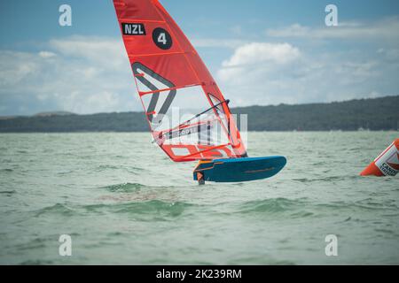 Ein Mann nimmt an einem nationalen Windsurf-Hydrofoil-Rennen beim Waterbourne Watersports Festival, Takapuna Beach, Auckland, Neuseeland, Teil. Stockfoto