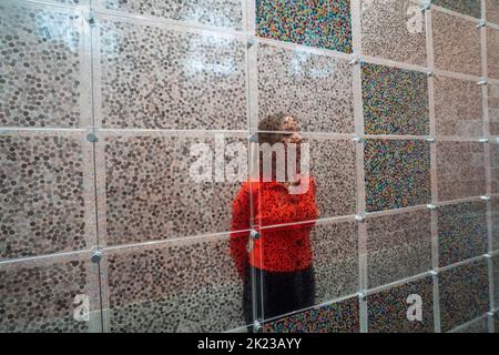 London, Großbritannien. 22. September 2022. Ein Newport-Mitarbeiter sieht Arbeiten an der Vorschau von „The Currency“ von Damien Hirst, die aus 10.000 NFTs besteht, was 10.000 einzigartigen physischen Kunstwerken entspricht, die Hirst geschaffen hat, wo Sammler die NFT behalten oder gegen das physische Kunstwerk austauschen konnten. Die Ausstellung läuft vom 23. September bis 30. Oktober in der Newport Street Gallery Lambeth und Kunstwerke werden verbrannt, wenn die Ausstellung zu Ende geht. Kredit: amer ghazzal/Alamy Live Nachrichten. Stockfoto