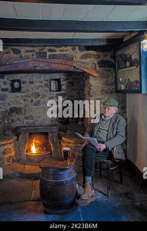 .Mann, der mit einem Glas Pint im Blue Anchor Inn in Helston, Cornwall, England sitzt. Stockfoto