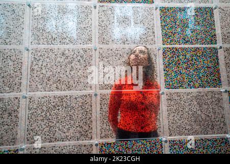 London, Großbritannien. 22. September 2022. Ein Newport-Mitarbeiter sieht Arbeiten an der Vorschau von „The Currency“ von Damien Hirst, die aus 10.000 NFTs besteht, was 10.000 einzigartigen physischen Kunstwerken entspricht, die Hirst geschaffen hat, wo Sammler die NFT behalten oder gegen das physische Kunstwerk austauschen konnten. Die Ausstellung läuft vom 23. September bis 30. Oktober in der Newport Street Gallery Lambeth und Kunstwerke werden verbrannt, wenn die Ausstellung zu Ende geht. Kredit: amer ghazzal/Alamy Live Nachrichten. Stockfoto