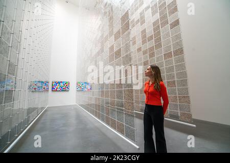 London, Großbritannien. 22. September 2022. Ein Newport-Mitarbeiter sieht Arbeiten an der Vorschau von „The Currency“ von Damien Hirst, die aus 10.000 NFTs besteht, was 10.000 einzigartigen physischen Kunstwerken entspricht, die Hirst geschaffen hat, wo Sammler die NFT behalten oder gegen das physische Kunstwerk austauschen konnten. Die Ausstellung läuft vom 23. September bis 30. Oktober in der Newport Street Gallery Lambeth und Kunstwerke werden verbrannt, wenn die Ausstellung zu Ende geht. Kredit: amer ghazzal/Alamy Live Nachrichten. Stockfoto