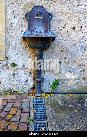 Öffentliche Wasserversorgung, Wasserhahn mit Trinkwasseranschluss und Spüle im Stadtmuseum Klostermühle, Bad Urach, Schwäbische Alb, Deutschland. Stockfoto