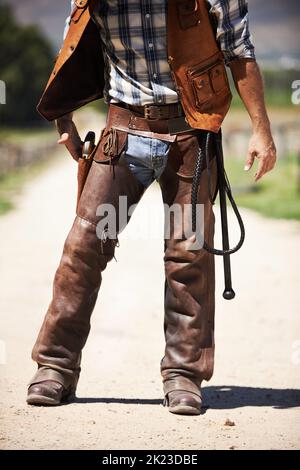 Ein nicht erkennbarer Cowboy, der seine Waffe zieht. Stockfoto