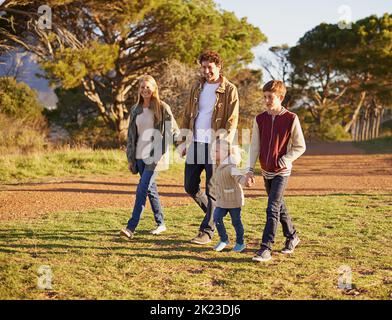 Auf einem gemütlichen Familienspaziergang. Eine junge Familie genießt einen Spaziergang im Freien. Stockfoto