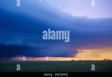 Atemberaubende Farben des Sonnenuntergangs, wie der Blitz unter einem heftigen supercell-Gewitter in Oklahoma, USA, aufschlägt Stockfoto