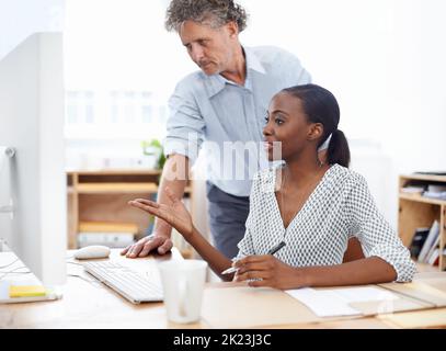 Erläuterung des Problems. Eine Mitarbeiterin und ihr Chef diskutieren über die Arbeit in ihrem Büro. Stockfoto