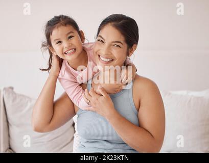 Frau mit glücklichen Mädchen, Lächeln im Schlafzimmer mit Schlafanzug am Morgen am Wochenende oder im Urlaub. Asiatische Mutter mit Kind im Bett, drücken Liebe und Glück, in Stockfoto