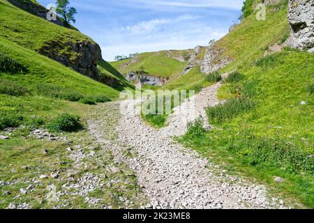 Der felsige Pfad, der durch Cave Dale, Castleton, hinaufführt, zweigt nach rechts ab. Stockfoto