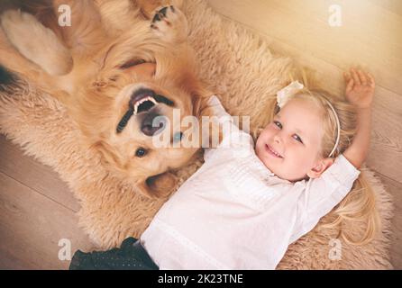 Der beste Freund, den du bekommen kannst. Ein entzückendes kleines Mädchen mit ihrem Hund zu Hause. Stockfoto