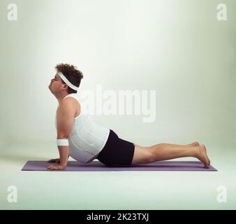 Diese nach oben schauenden Hundehaltung ist groß. Ein übergewichtiger Mann, der Yoga-Posen macht. Stockfoto