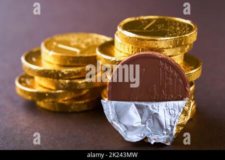 Schokoladenmünze. Hintergründe von Schokolade Euro-Münze Geld auf braunem Hintergrund. Euro-Münzen übereinander gestapelt in verschiedenen Positionen. Eine Gruppe von Münzen. Stockfoto