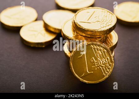 Schokoladenmünze. Hintergründe von Schokolade Euro-Münze Geld auf braunem Hintergrund. Euro-Münzen übereinander gestapelt in verschiedenen Positionen. Eine Gruppe von Münzen. Stockfoto