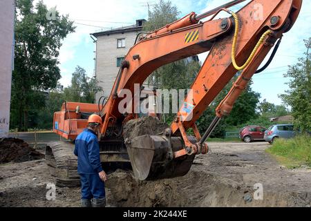 Bagger führt Erdarbeiten in der Stadt. Hochwertige Fotos Stockfoto