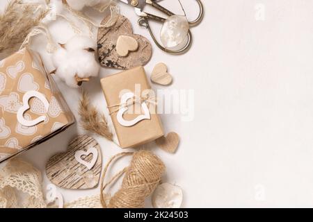 Valentinstag Geschenke in Kraftpapier gewickelt und mit Vintage-Spitze, Herzen und Pampass Gras von oben Blick dekoriert. Frühling rustikal, Cottage chic oder bohe Stockfoto