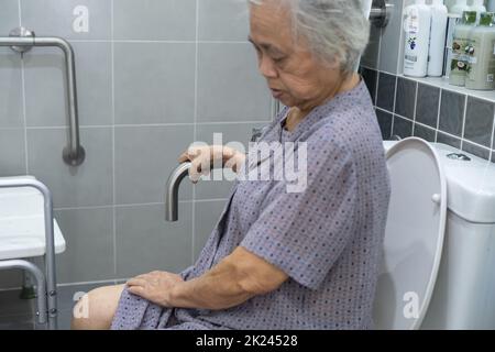 Asiatische ältere oder ältere alte Dame Frau Patienten verwenden Toilette Badezimmer Griff Sicherheit in Krankenpflege-Station, gesund starke medizinische Konzept. Stockfoto