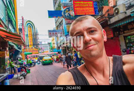 Weltreise Rucksacktouristen in China Town Bangkok, während starker Verkehr. Kannst du jetzt noch in Thailand Rucksack tragen? Stockfoto