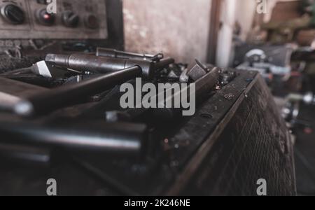 Selektiver Fokus auf Werkzeug zur Aufnahme des Werkstücks auf der Drehmaschine. Drehmaschine im Werk. Drehmaschine für die Metallbearbeitung. Hersteller von schweren Maschinen Stockfoto