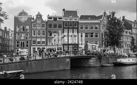 Ein schwarz-weiß Bild von einer Gruppe von Gebäuden auf den Rand einer Gracht in Amsterdam. Stockfoto