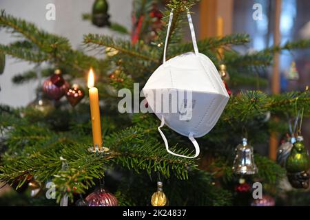 FFP2-Maske hängt auf einem Weihnachtsbaum, Österreich, Europa - FFP2 Maske hängt an einem Weihnachtsbaum, Österreich, Europa Stockfoto