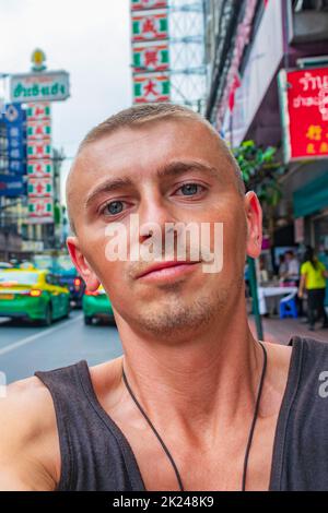 Weltreise Rucksacktouristen in China Town Bangkok, während starker Verkehr. Kannst du jetzt noch in Thailand Rucksack tragen? Stockfoto