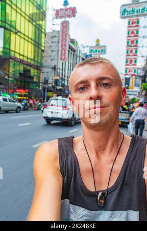 Weltreise Rucksacktouristen in China Town Bangkok, während starker Verkehr. Kannst du jetzt noch in Thailand Rucksack tragen? Stockfoto