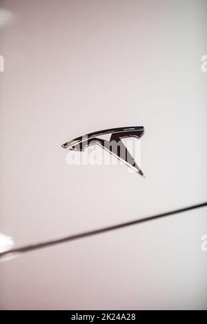 BUKAREST, RUMÄNIEN - 10. Oktober 2021: Illustrative redaktionelle Darstellung das Tesla-Logo auf der Motorhaube eines weißen Autos. Stockfoto