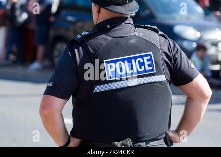 Polizist/Polizist, der bei einer öffentlichen Veranstaltung im Dienst ist und eine stechfeste Weste trägt, die Teil seiner Uniform ist. London. UK(132) Stockfoto