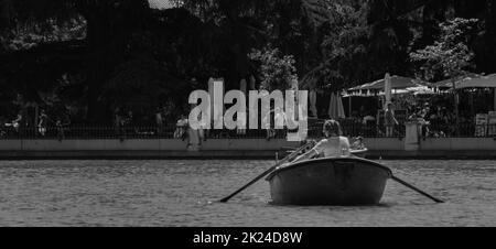 Ein schwarz-weiß Bild von zwei Jugendlichen Rudern ein Boot in Parque del Retiro. Stockfoto