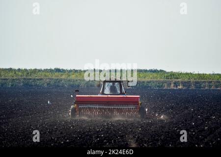 Traktor. Landmaschinen Traktor. Traktor mit einer Sämaschine im Feld. die Aussaat Samen in der Erde. Stockfoto