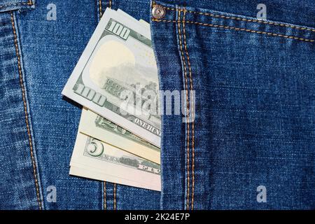 Dollar ragen aus der Tasche der Jeans. Geld in der Tasche. Stockfoto