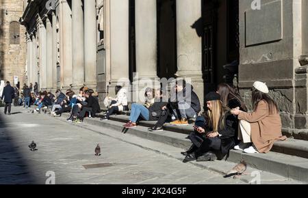 Florenz, Italien. 2022. Januar. Touristen sitzen auf den Stufen in den Uffizien im Stadtzentrum Stockfoto