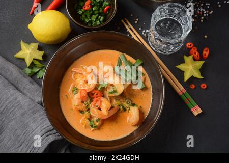 Thailändische Garnelen rotes, rotes, rotes, rotes, Thailand Tradition rote-Burschsuppe mit Garnelen Garnelen und Kokosmilch. Panaeng Curry und dunkler Hintergrund. Stockfoto