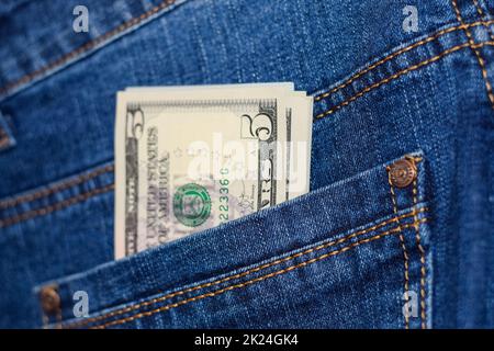 Dollar ragen aus der Tasche der Jeans. Geld in der Tasche. Stockfoto