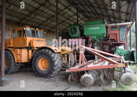 Russland, Poltavskaya Dorf - 6. September 2015: Großer Traktor mit Scheibenegge auf dem Anhänger. Mähdrescher. Landwirtschaftliche Maschinen. Stockfoto