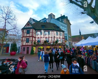 Colmar, Frankreich - 30. Dezember 2021: Menschen, die mit Weihnachtsschmuck auf die Straße gehen, in Colmar, im Elsass, Frankreich. Stockfoto