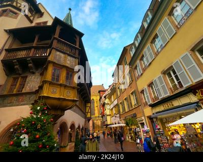 Colmar, Frankreich - 30. Dezember 2021: Menschen, die mit Weihnachtsschmuck auf die Straße gehen, in Colmar, im Elsass, Frankreich. Stockfoto