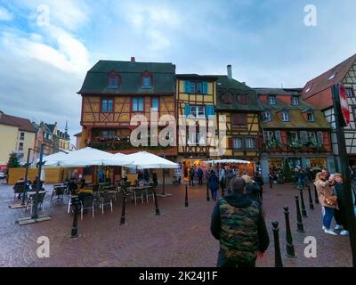 Colmar, Frankreich - 30. Dezember 2021: Menschen, die mit Weihnachtsschmuck auf die Straße gehen, in Colmar, im Elsass, Frankreich. Stockfoto