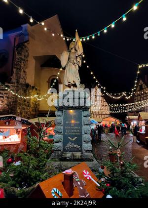 Eguisheim, Elsass, Frankreich - 30. Dezember 2021: Touristen wandern entlang der Grand-Rue-Straße, zwischen bunten Fachwerkhäusern Stockfoto