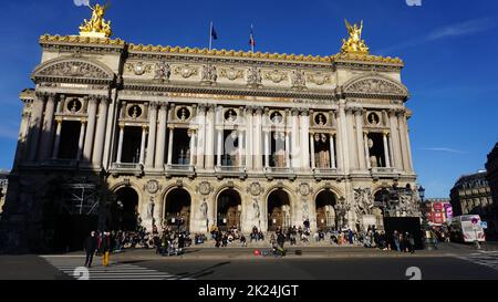 Paris, Frankreich - 01. Januar 2022: Menschen, die sich in der Nähe der Opera National de Paris ausruhen. Grand Opera oder Garnier Palace ist ein berühmtes neobarockes Gebäude in Paris, Stockfoto