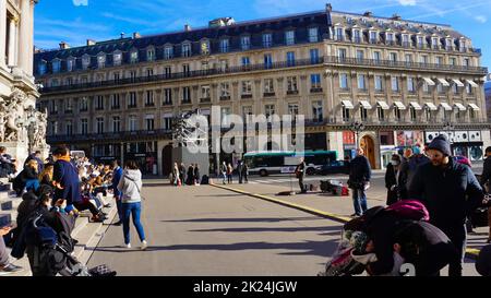 Paris, Frankreich - 01. Januar 2022: Menschen, die sich in der Nähe der Opera National de Paris ausruhen. Grand Opera oder Garnier Palace ist ein berühmtes neobarockes Gebäude in Paris, Stockfoto