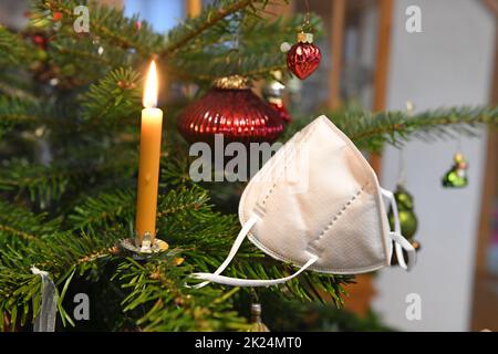 FFP2-Maske hängt auf einem Weihnachtsbaum, Österreich, Europa - FFP2 Maske hängt an einem Weihnachtsbaum, Österreich, Europa Stockfoto