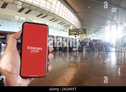 Dubai, VAE Oktober 2021: Hand halten ein Smartphone mit der Emirates App auf dem Bildschirm im Flughafen. Emirates ist die größte Fluggesellschaft der Vereinigten Arabischen Emirate Stockfoto